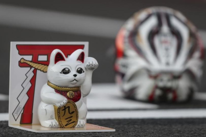 El gato que atrae a la suerte, junto al casco de Marc Márquez, en el box de Motegi en 2016.