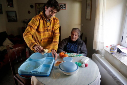 Una vecina de Santas Martas, de 101 años, recibe su menú de manos del trabajador social de Afadeva.