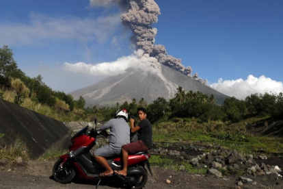 Aldeanos filipinos escapan a un área segura mientras el volcán Mayon entra en erupción.