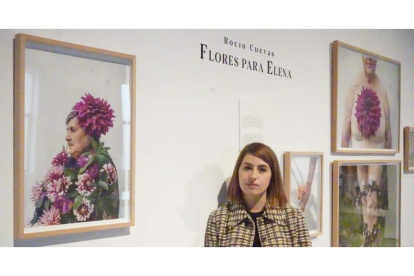 La fotógrafa Rocío Cuevas posa junto a su propuesta ‘Flores para Elena’. J. NOTARIO