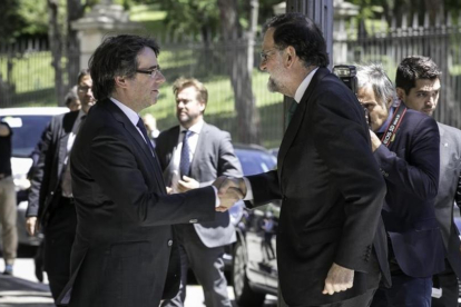 Carles Puigdemont y Mariano Rajoy se saludan este viernes, en Barcelona, antes de la inauguración del Salón de Automóvil de Barcelona.