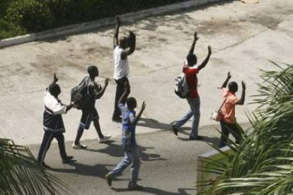 Civiles caminan con las manos en alto para mostrar que van desarmados en Abiyán.
