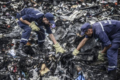 Dos agentes buscan entre los restos del vuelo MH17 de Malaysia Airlines, el pasado 20 de julio en Donetsk (Ucrania).