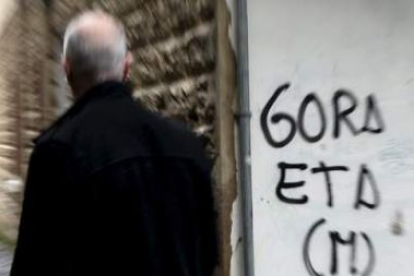 Un hombre pasa junto a una pintada de apoyo a ETA en una calle de San Sebastián.