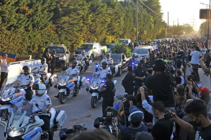 Decenas de hinchas caminan detrás del cortejo fúnebre que traslada los restos de Diego Armando Maradona, el jueves. ENRIQUE GARCÍA MEDINA