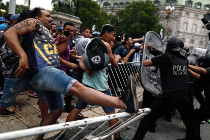 Varias personas se enfrentan a efectivos de la Policía a las puertas de la Casa Rosada donde este jueves se ha abierto la capilla ardiente de Diego Armando Maradona. JUAN IGNACIO RONCORONI