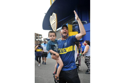 Un padre junto a su hijo, durante el luto a Maradona. ENRIQUE GARCÍA MEDINA