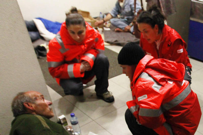Voluntarios de Cruz Roja junto a personas sin techo.