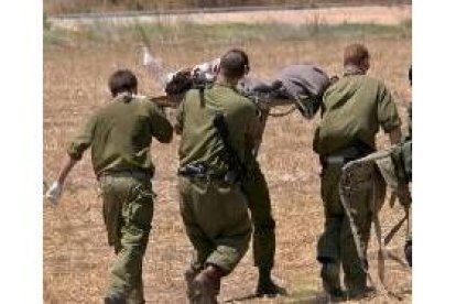 Militares israelíes evacúan a un compañero herido por los misiles lanzados por Hezbolá