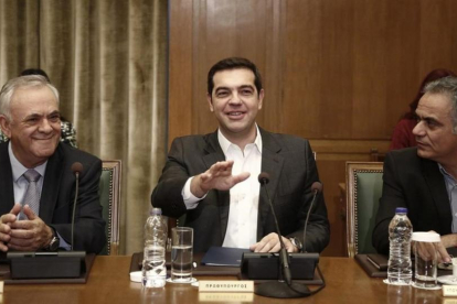 Tsipras (centro) gesticula junto al viceprimer ministro Yiannis Dragasakis (izq) y el ministro de Interior, Panagiotis Skurletis, en el consejo de ministros celebrado en el Parlamento, en Atenas, este domingo.