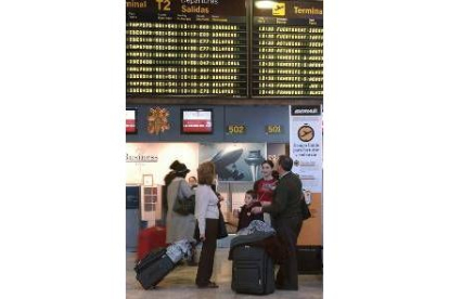 Varios pasajeros ante una de las terminales de Barajas