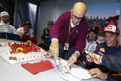 Carmelo Ezpeleta reparte, en presencia de Marc Márquez y sus compañeros, el pastel de su 70 cumpleaños.