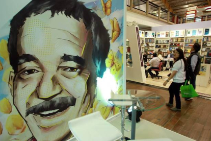 Una pareja pasa frente a una ilustración de Gabriel García Márquez en la Feria Internacional del Libro de Bogotá