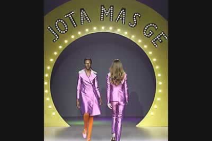 La firma Jota más Ge viste a la mujer con trajes de raso en tonos púrpuras que contrastan con las medias naranjas.