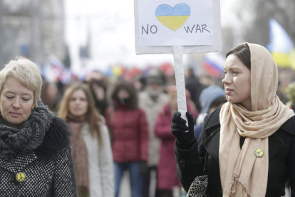 Una rusa porta una pancarta en contra de la guerra y de las acciones militares en Ucrania.