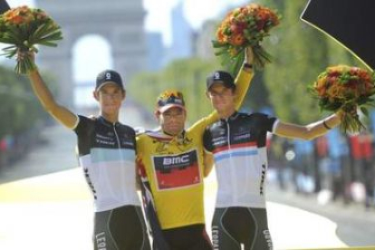 Cadel Evans, en el centro, celebra su victoria en la general del Tour, junto a los hermanos luxembur