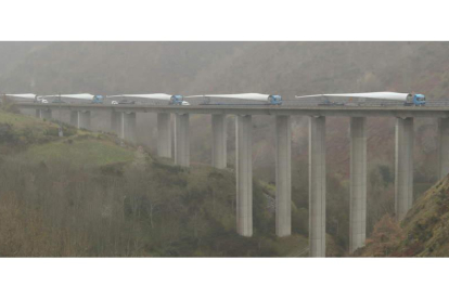 Un convoy de camiones, cargados con palas eólicas procedentes de Ponferrada, ayer por la A-6 en el viaducto de Río Lamas (Vega de Valcarce) hacia Galicia. L. DE LA MATA