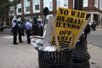 Una de las pancartas que formó parte de la manifestación con el lema 'No a la guerra en Irán! Fuera las manos de Syria!' arrojada en una papelera tras la concentración. Foto: RICARDO MIR DE FRANCIA / Chicago