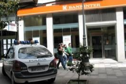 El vehículo policial aparcado enfrente de la entidad financiera