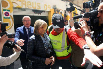 La primera teniente de alcalde del Ayuntamiento de Reus, Teresa Gomis, acompañada del alcalde de la localidad, Carles Pellicer (CiU) (izquierda), sale detenida por la puerta de atrás del ayuntamiento, el martes 28 de abril.