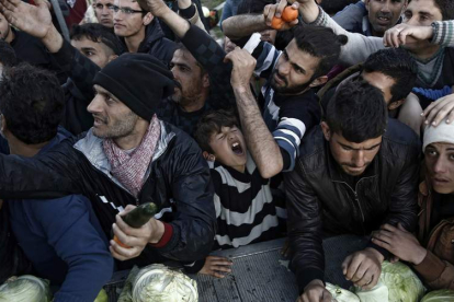 Varios refugiados pelan por comida en un campo de refugiados de Grecia. YANNIS KOLESIDIS