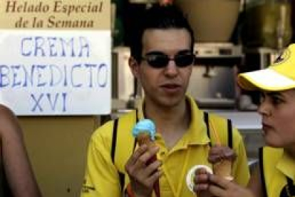 Dos peregrinos en una heladería que oferta como producto de la semana la «Crema Benedicto XVI»