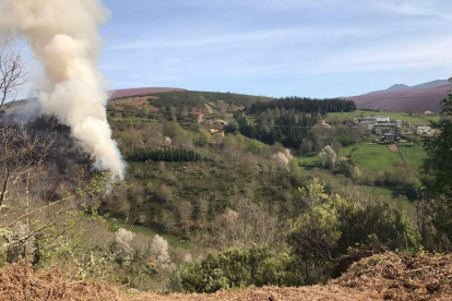 La columna de humo del incendio avanzaba hacia Castañeiras (derecha) ayer por la mañana. DL