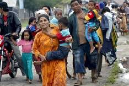 Una madre huye con su familia después de recibir el aviso de que otro terremoto podría azotar Gunung