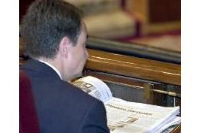 Zapatero lee los periódicos durante la segunda sesión del debate el estado de la nación