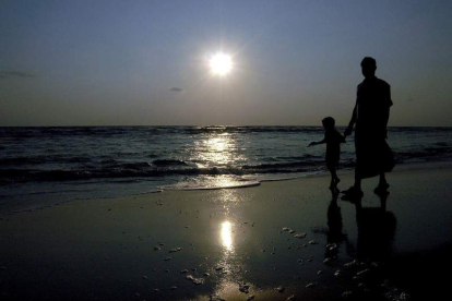 Un hombre y su hijo pasean por la playa en una de las islas de Andamán, en la India. MANJUNATH KIRAN
