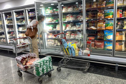Una mujer busca un producto en un lineal de frío de un supermercado. MIGUEL GUTIÉRREZ