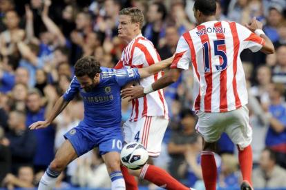 Juan Mata, izquierda, lucha por el balón con Robert Huth, centro, del Stoke City.