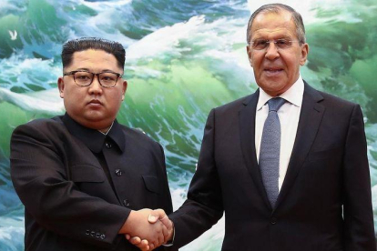 El mandatario norcoreano Kim Jong-un y el ministro de Exteriores ruso Sergéi Lavrov se estrechan la mano durante una reunión en Pionyang este jueves.