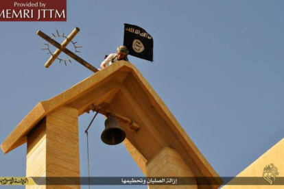 Terroristas del Estado Islámico colocan su bandera en una iglesia cristiana en el norte de Irak.