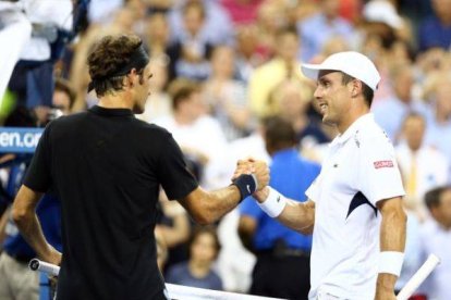 Federer y Roberto Bautista se dan la mano tras el partido.