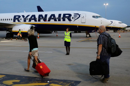 Pasajeros se dirijen a un avión de la compañia Ryanair en un aeropuerto de Londres