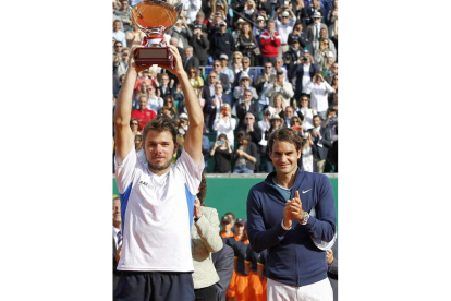 Wawrinka levanta el trofeo ante los aplausos de Federer.