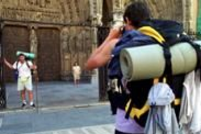 Dos peregrinos se fotografían frente a la Catedral de León