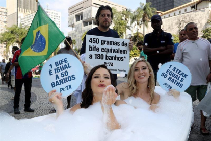 Dos activistas de la organización Personas a favor del Trato Ético a los Animales (PETA, en inglés) se bañan en una tina en el centro de Río de Janeiro hoy para denunciar que el consumo de carne supone el despilfarro de grandes cantidades de agua.