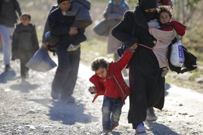 Una familia de refugiados se dirige a la frontera de Macedonia con Serbia.