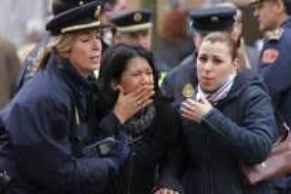 Los policías intentan calmar a una mujer en el escenario de la explosión