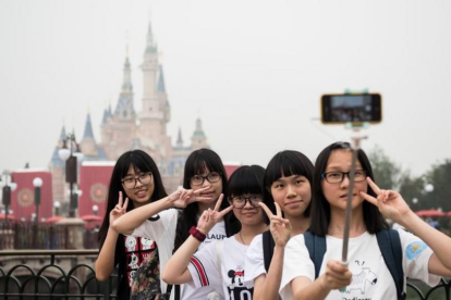 Unas visitantes al nuevo parque Disney en hacen un selfie durante la ceremonia de inauguración.