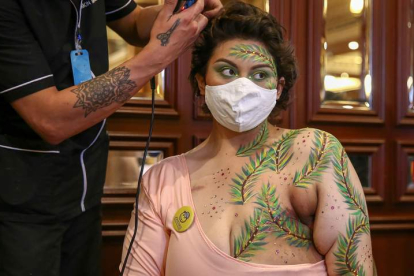 Un artista pinta con motivos florales las cicatrices de las mastectomías de una mujer en Quito (Ecuador). JOSÉ JACOME