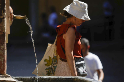 Una mujer pasa junto a una fuente en Córdoba. RAFA ALCAIDE
