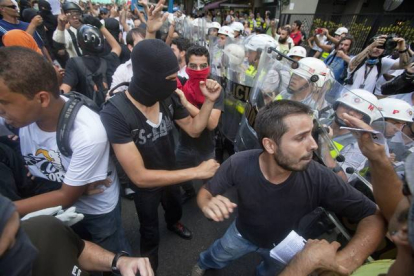 Agentes de policía intentan reducir a manifestantes que protestan contra la celebración del Mundial, este sábado en Sao Paulo.