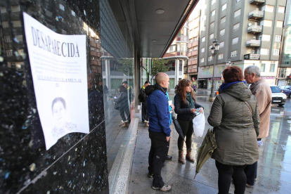 Voluntarios junto a un cartel con la foto de la anciana. L. DE LA MATA