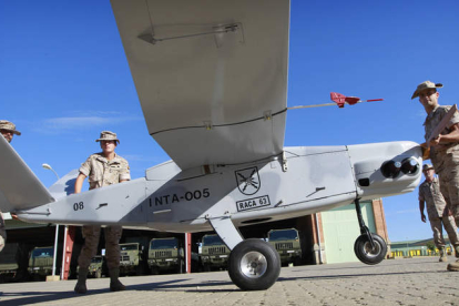 Varios miembros del Raca 63 transportan un modelo de avión no tripulado, similar a los que se envían desde Israel en misión de vigilancia a Afganistán, en la base ‘Conde de Gazola’ en Ferral del Bernesga.