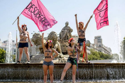 Las activistas de Femen han protestado contra la 'ley mordaza' en la fuente Cibeles, en Madrid.