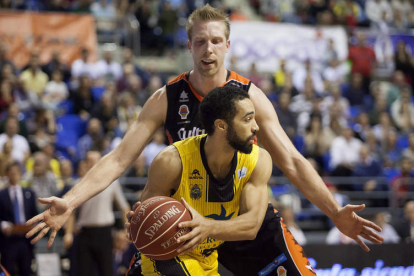 Justin Hamilton, del Valencia Basket, trata de frenar al base del Iberostar Tenerife, White.