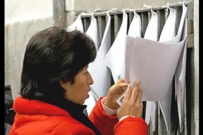 Una ciudadana ecuatoriana consulta las listas del censo en un colgio de Madrid.